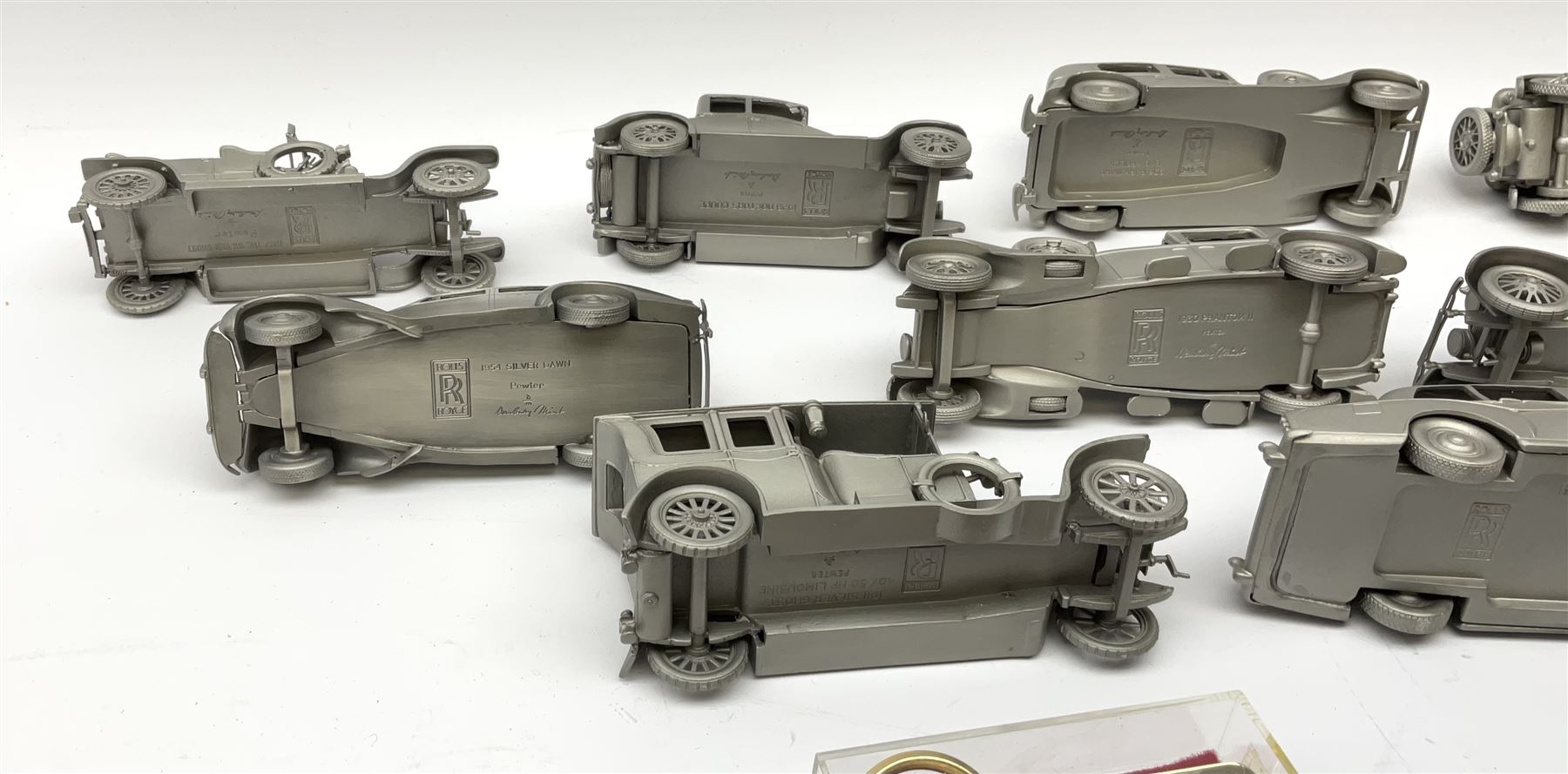 Twelve Danbury Mint pewter models of vehicles including Rolls Royce '1936 Park Ward Baby Rolls', Rolls Royce '1907 The Silver Ghost' etc and a small number of pin badges and car fobs