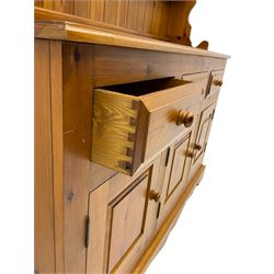 Pine farmhouse dresser with three drawers and three cupboards, and two tier plate rack