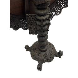 Late 19th century Anglo-Indian carved hardwood occasional table, circular tilt-top carved profusely with mythical animals and foliage decoration, pierced and carved with interlaced leafy branches, leaf carved pedestal supports on a raised platform with further carved and pierced foliage decoration, four carved feet in the form of mythical beasts with gaping jaws 