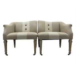 Pair of contemporary hardwood corner chairs, upholstered in broad alternating bands of neutral-toned fabric, each with two knotted rope buttons to the backrest, the whole raised on turned and lightly whitewashed supports terminating in castors