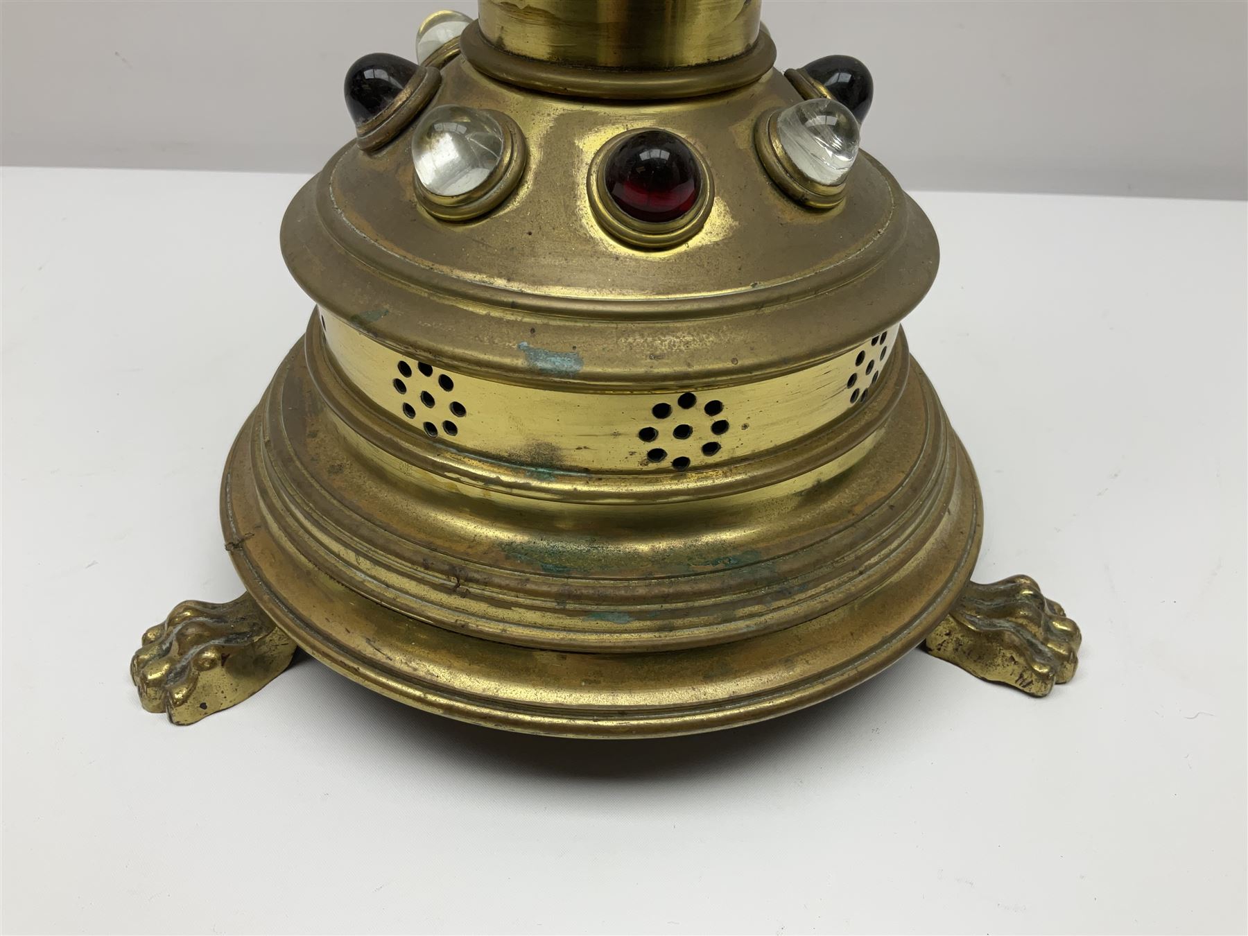 Brass alter cross, decorated with glass cabochons, upon a acicular stepped base and three claw feet, H73cm 