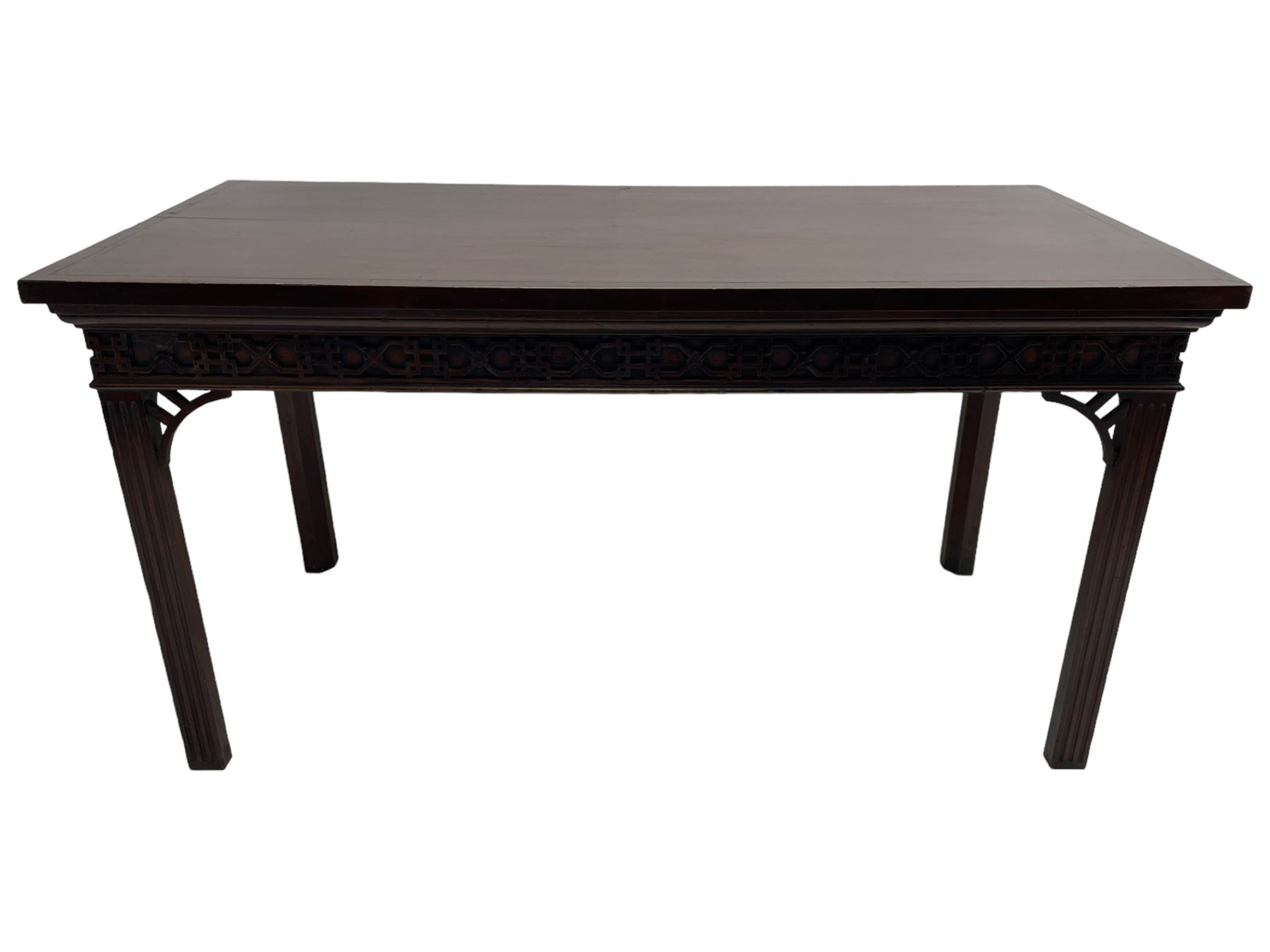 In the manner of Thomas Chippendale - early 19th century mahogany serving table, rectangular crossbanded top with boxwood stringing, the frieze with upper moulding over applied geometric fretwork, the left-hand side fitted with slide, on fluted square supports with inner chamfer 