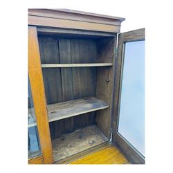 Late 19th century oak display cabinet, rectangular form with a pair of glazed doors enclosing shelves, raised on cabriole supports with carved detailing ending in claw feet
