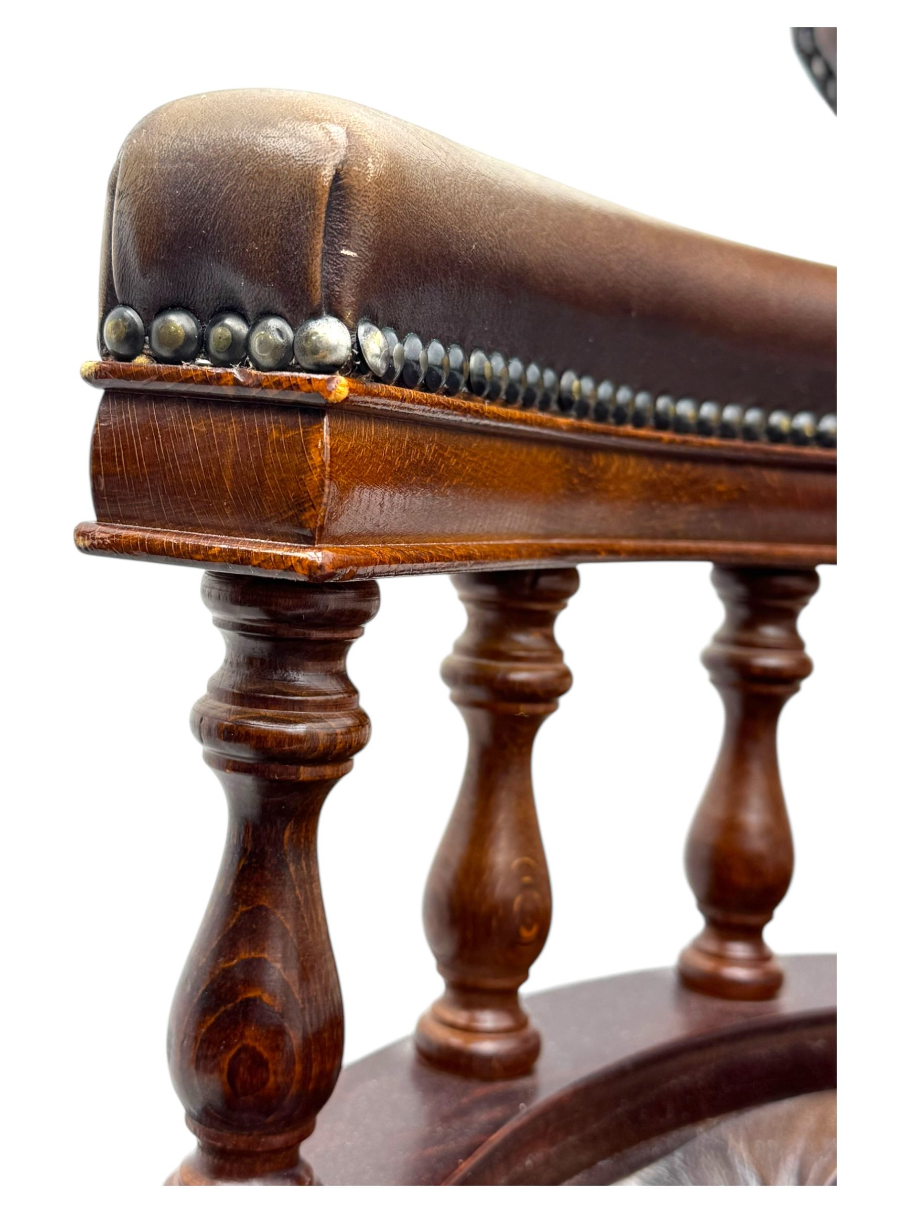 Mahogany framed swivel Captains desk chair, upholstered in brown buttoned leather, turned supports and swivel base on castors