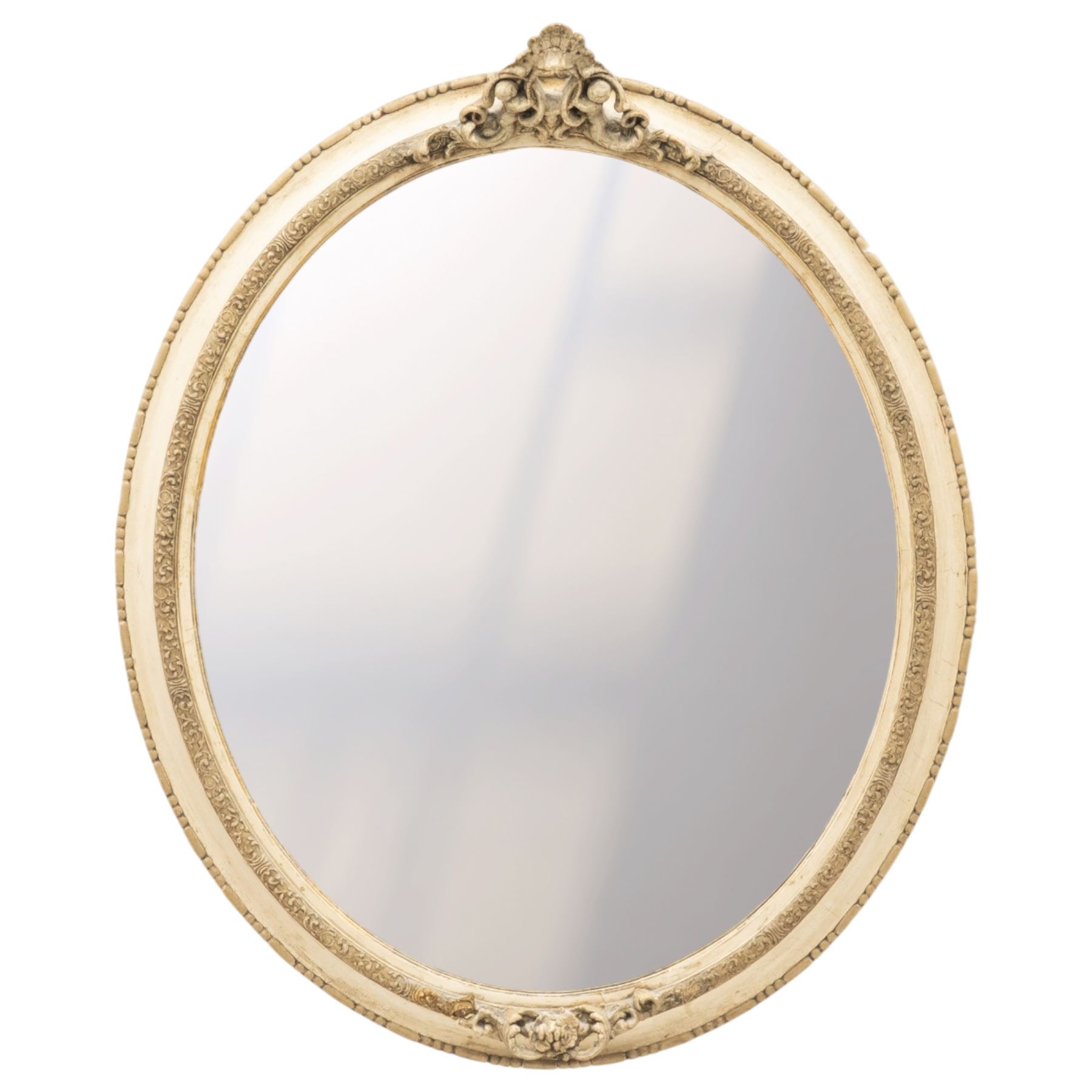 Early 20th century cream and parcel-gilt oval wall mirror with mer-putti pediment