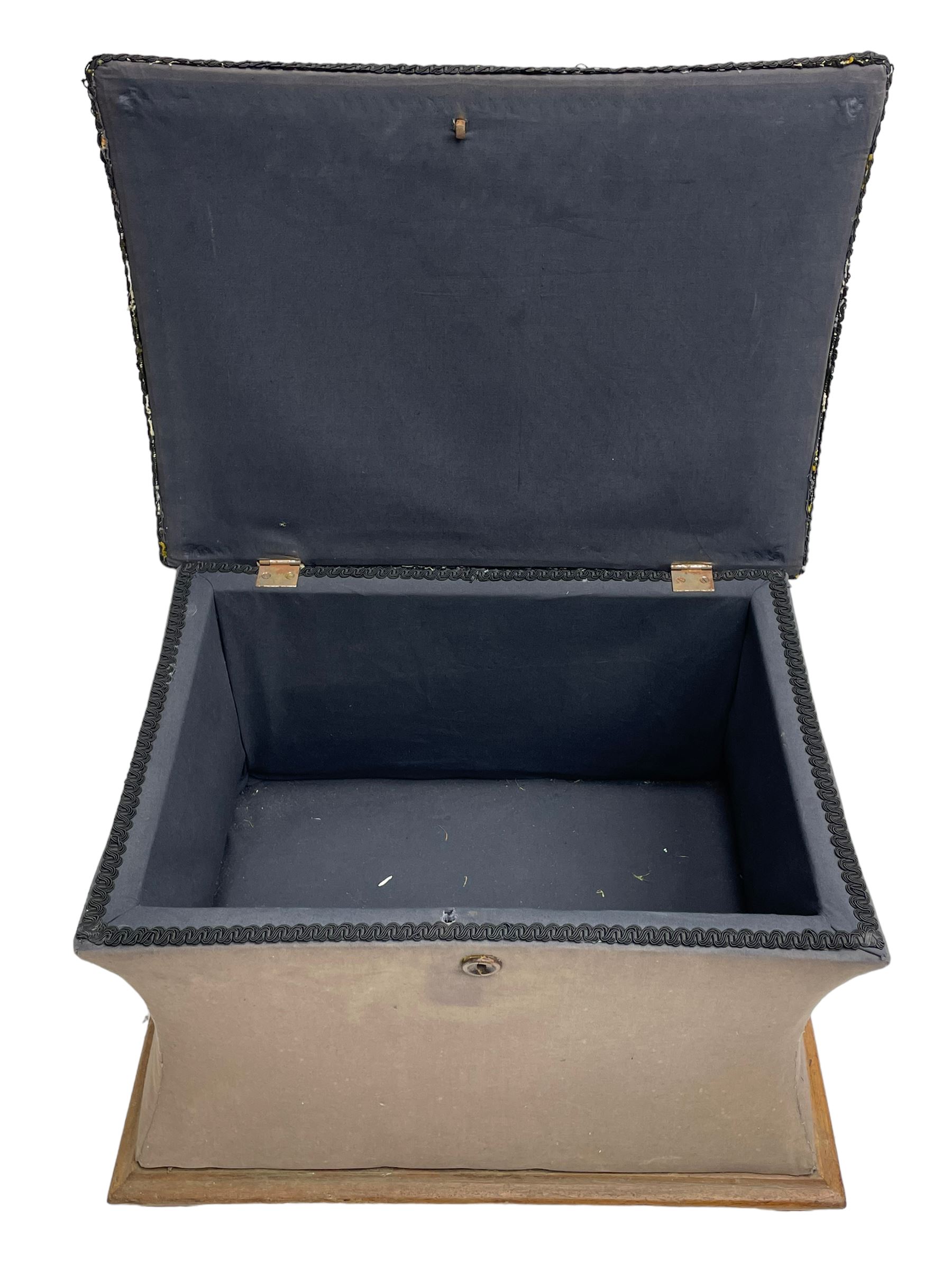 19th century upholstered ottoman, rectangular waisted form with hinged lid, upholstered in needle work cover decorated with floral panels and borders, the interior lined in blue fabric, lower moulded edge over compressed bun feet