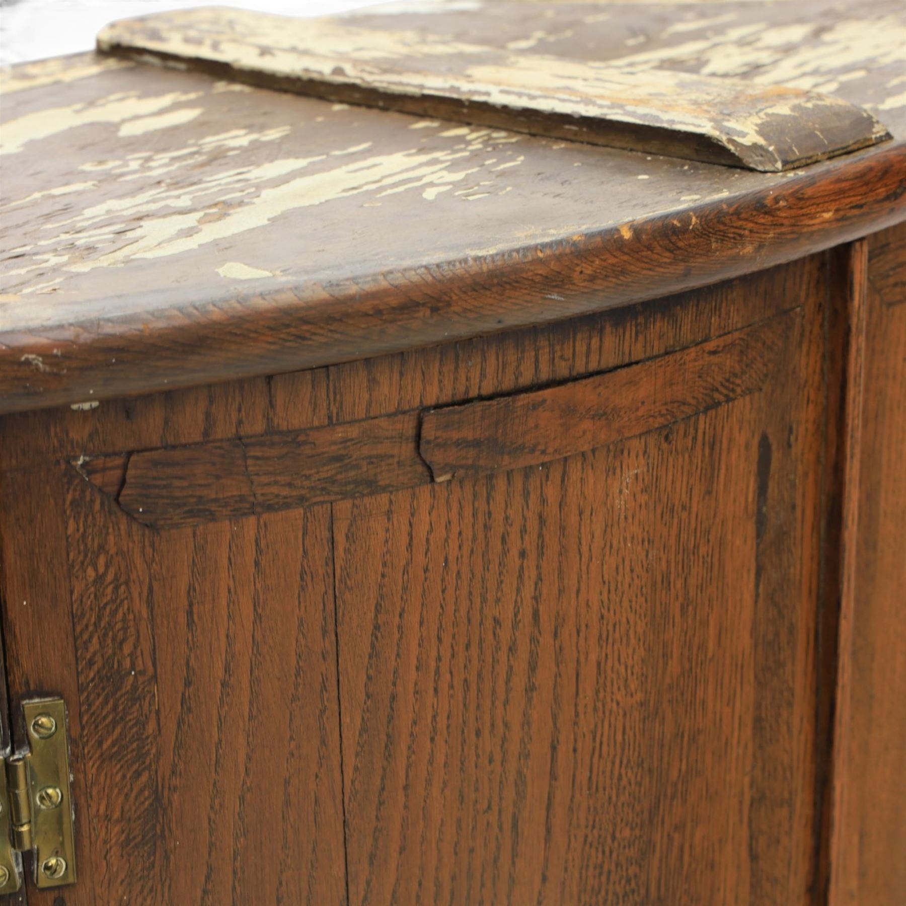 George III oak cylindrical corner cupboard, bow fronted doors revealing a painted shelved interior, brass escutcheons  and hinges, raised on a moulded plinth base
