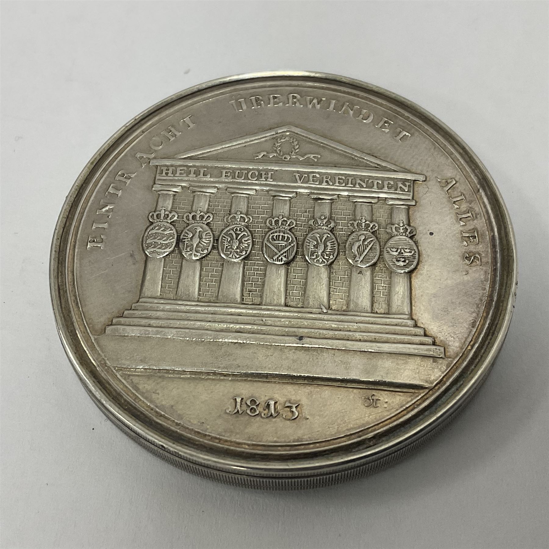 Grolier Club’s silver Schraubmedaille to commemorate the German campaign of 1813, obverse depicts a Greek temple, below “Eintracht Überwindet Alles”, the reverse depicts three figures and the text “Gerechtigkeit. Weisheit. U. Einigkeit. Beglücken. D.: Menschheit”, inside are twelve circular hand coloured engravings depicting six major battles of the German campaign, each with corresponding descriptions, D