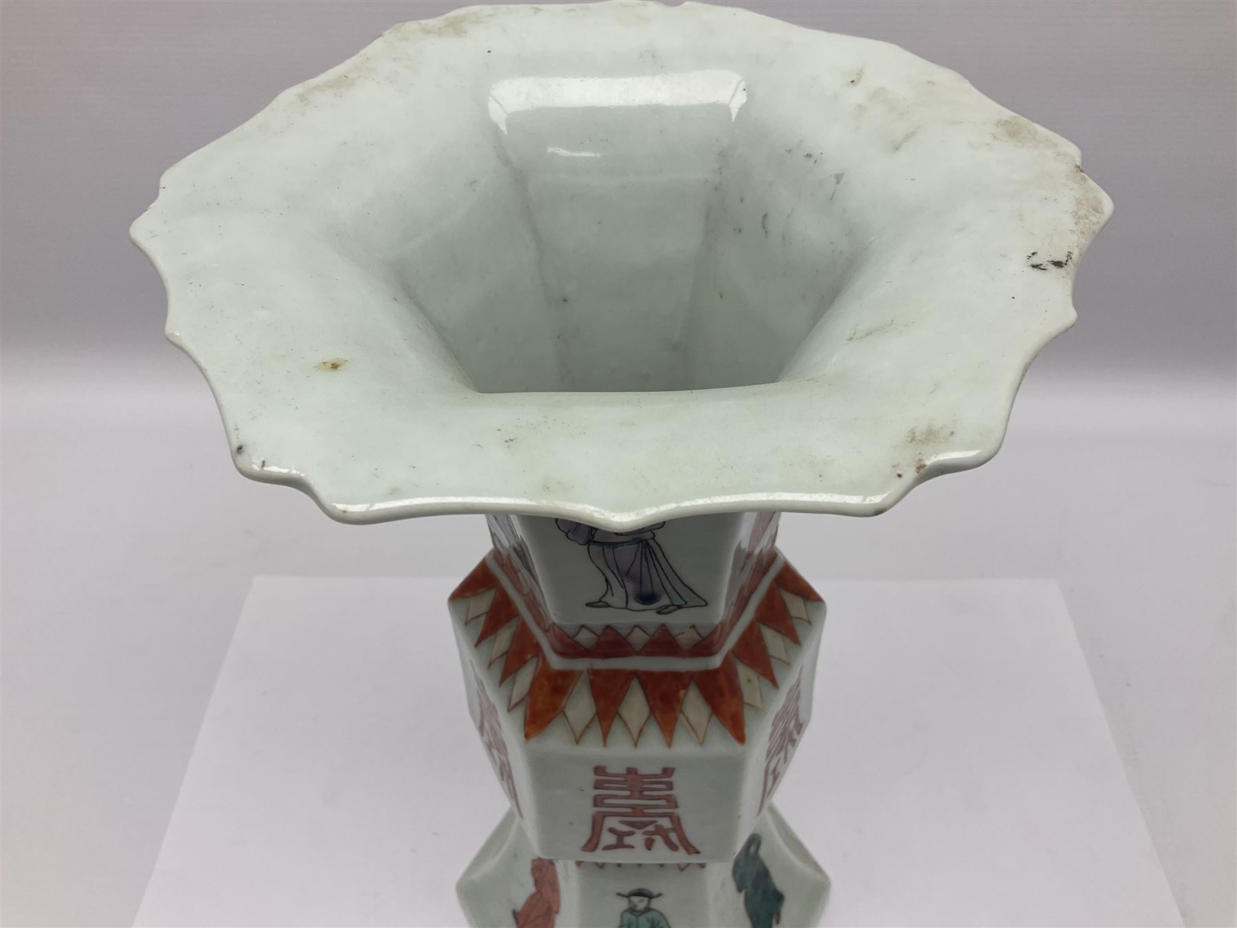Chinese Kangxi gu vase, of hexagonal form with fluted rim, decorated in polychrome enamels with a male figure to each panel and red character marks to centre, with painted red leaf mark beneath, H32.5cm