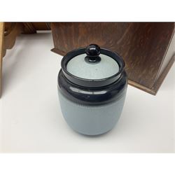 Early 20th century oak smokers cabinet, with brass shield shaped mounts, opening to reveal a compartmentalised interior with three drawers, pipe rack and tobacco jar, together with a small wooden shelf, smokers cabinet H28.5cm