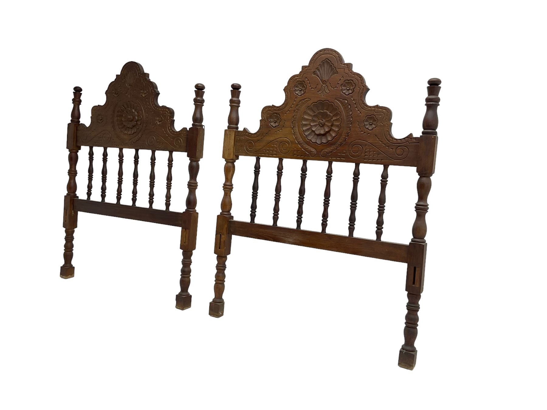 Pair Spanish stained beech single 3' bedsteads, spindle turned backs and carved with scrolling floral decoration 