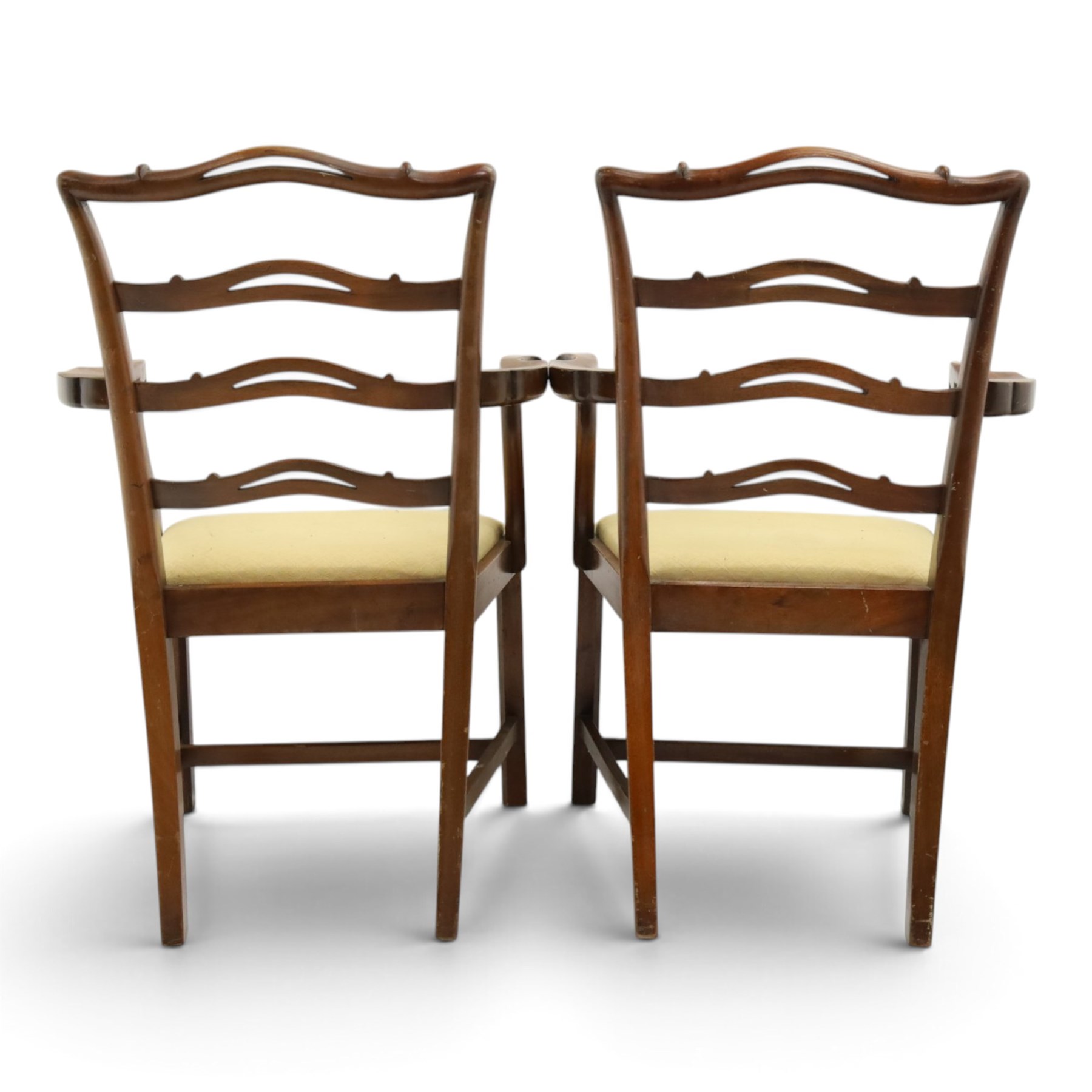 Pair of Georgian design Chippendale style mahogany elbow chairs, the pierced and waived ribbon ladder-back over scrolled arm terminals and yellow drop-in seats, on moulded and chamfered square supports