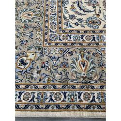 Large Fine Kashan carpet, ivory ground with interacting foliate designs and decorated with stylised flower heads, the multiple banded border decorated with scrolling foliage design with matching stylised flower heads, the outer guard signed by the weaver