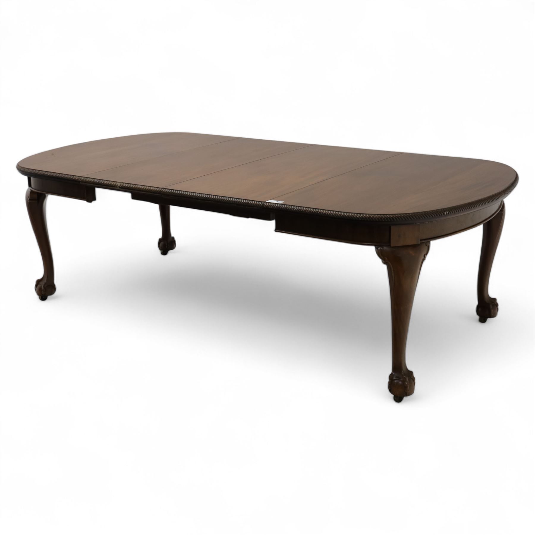 Early 20th century dining table, moulded oval top with gadroon carved edge, fitted with two additional leaves, raised on cabriole legs with shell carved knees and claw and ball feet