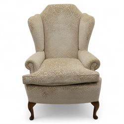 Late 20th century wingback armchair, upholstered in beige embossed fabric with brass stud edging, on cabriole legs and splayed rear legs