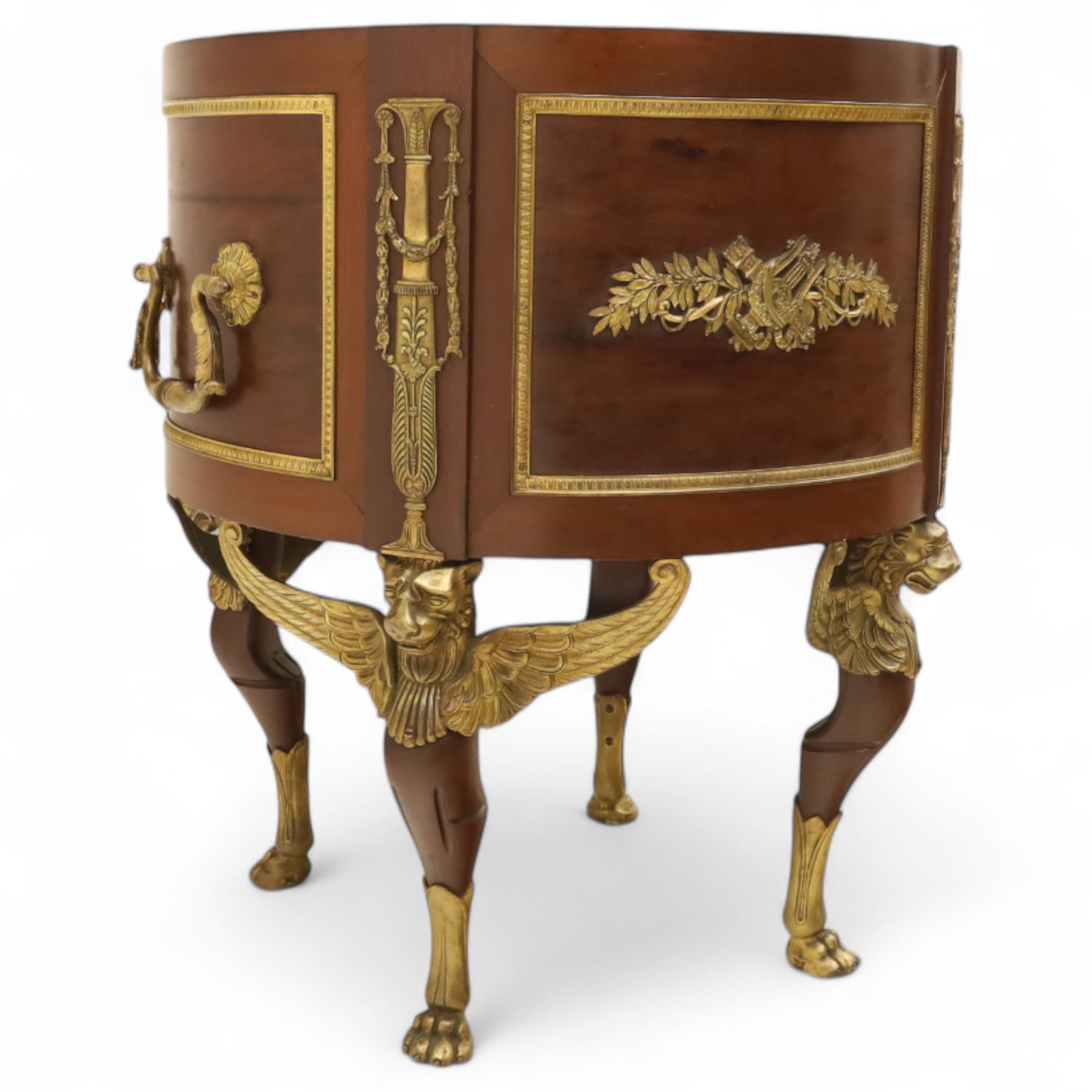 An imposing and richly adorned Empire Revival jardiniere of circular form, decorated with finely cast gilt bronze laurel garlands and floral swags, interior with a modern brass liner, sides with gilt bronze carrying handles, raised on three tripod legs with classical caryatid masks with wings terminating in lion paw feet, circa 1900

Provenance: This jardiniere formed part of the original furnishings of the opulent Empire Room at Kinloch Castle, built by industrialist George Bullough in 1900.

An original inventory number, ‘X954’, is inscribed on one facing, verifying its presence in the Kinloch Castle collection. This jardiniere epitomises the lavish taste of the Edwardian elite and the high standards of craftsmanship employed in the furnishing of Kinloch Castle, the first private home in Scotland to be lit by electricity and famed for its extravagant interiors.


