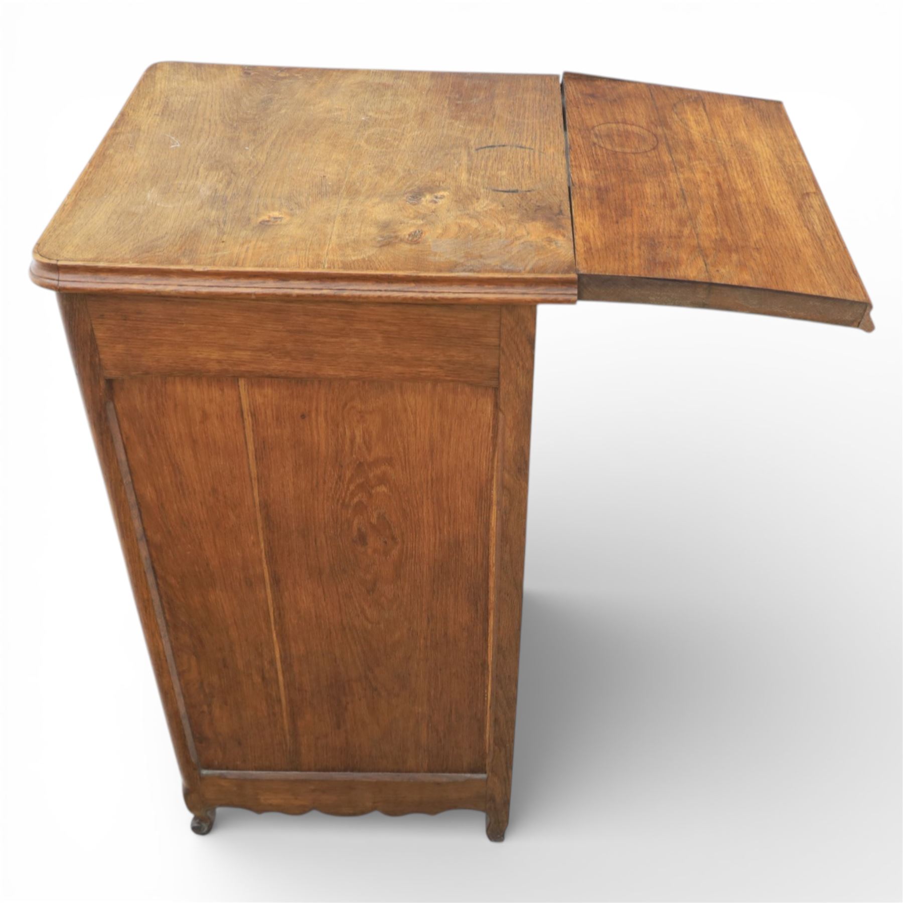 20th century French style oak bedside chest of pedestal form, the top with rounded moulded edge with drop leaf to the back, above five carved drawers with applied scroll ornament and turned knobs, the cupboard base with twin carved doors with diamond lattice panels, with shaped apron and bracket feet