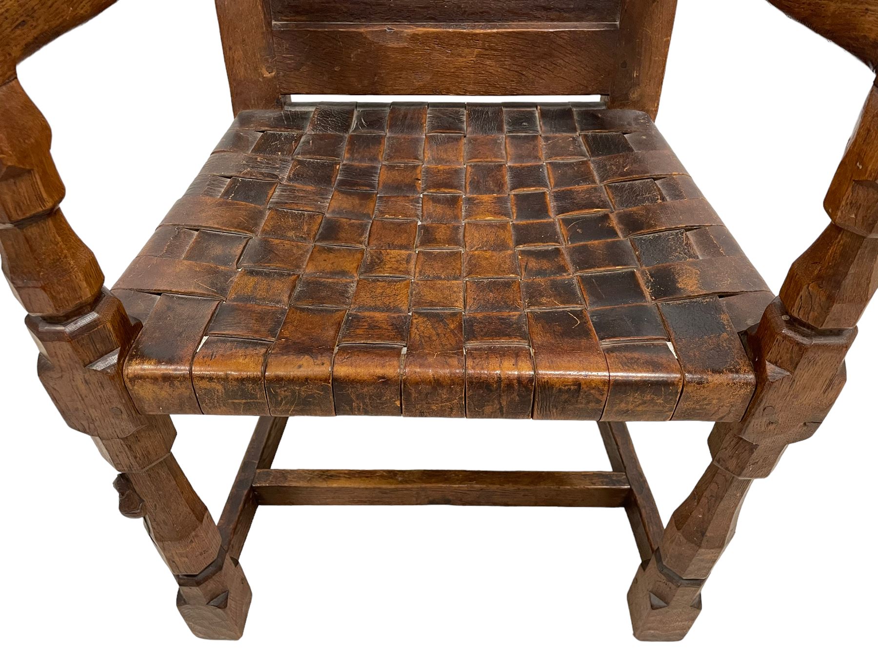 Mouseman - circa. 1930s set of six (4+2) oak dining chairs, panelled back carved with the Bagshawe family crest, the moto 'Forma Flos Fama Flatus' over an arm grasping a bugle-horn with ribbon tie and Yorkshire rose motif, adzed frame, leather lattice strap seat, on octagonal supports united by stretchers, two carvers and four side chairs, each carved with mouse signature, by Robert Thompson of Kilburn 

Provenance: Owned since manufacture by the Bagshawe family, descendants of the Staithes Group Artist Joseph Richard Bagshawe RBA (1870-1909).