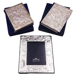 Two modern silver mounted bibles, the silver covered embossed with putti within a foliate surround, hallmarked Harman Brothers, Birmingham 1988 and 1989, together with a modern silver mounted photograph frame decorated with jack-in-a-box, rabbit and other motifs, and vacant panels for 'Name', 'Date', 'Time', and 'Weight', with easel style support verso, hallmarked Carr's of Sheffield Ltd, Sheffield 2013, overall H16cm W13.5cm