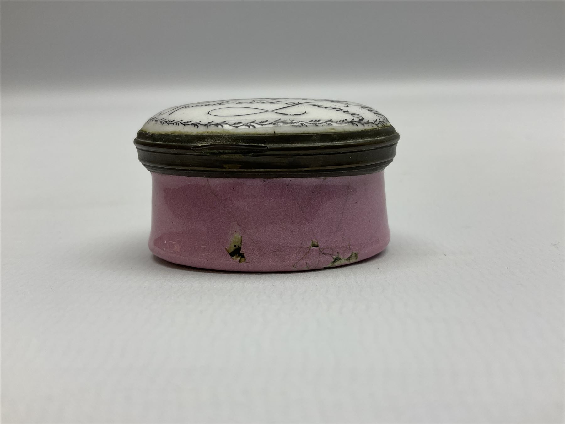 Late 18th century Staffordshire enamel patch box, of oval form with pink base, the hinged cover inscribed 'Have Communion with few, Be familiar with One, Deal justly with All, Speak evil of none' upon a white ground, opening to reveal mirror beneath, W4cm