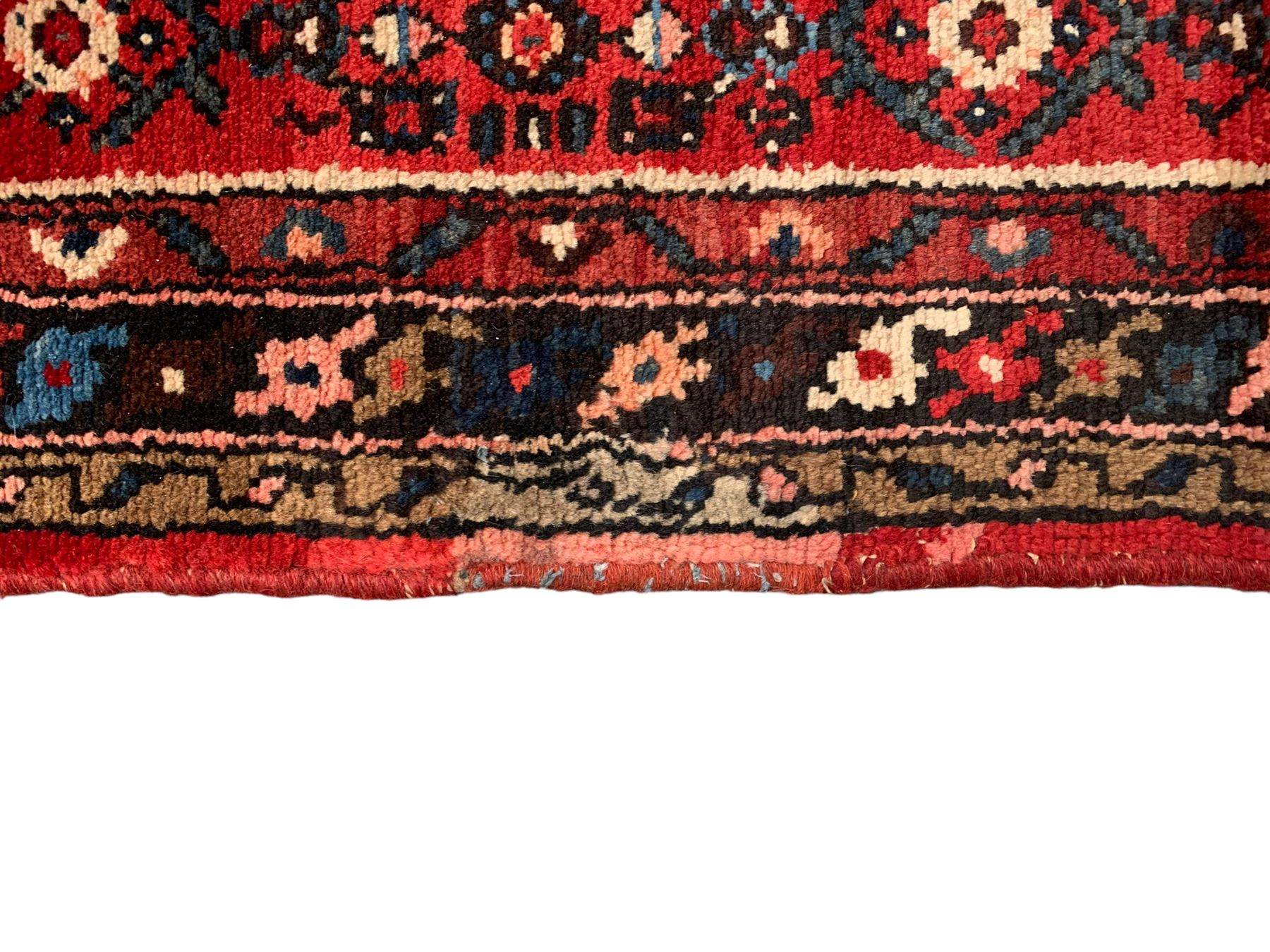 Persian crimson ground runner, the field decorated with Herati motifs,  three-band border, the main band decorated with repeating flowerheads 