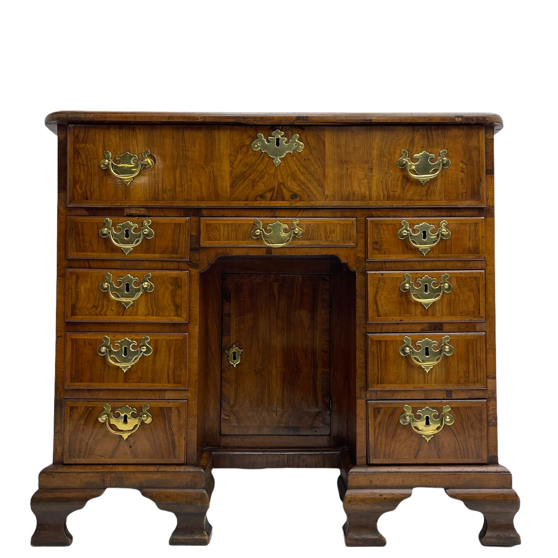 Early 18th century Queen Anne figured walnut kneehole desk with secretaire drawer, moulded and book matched top with walnut band, the top drawer with fall front enclosing small drawers and pigeon holes, fitted with nine drawers and central recessed cupboard, on ogee bracket feet
