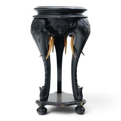Elephant ebonised jardinière, moulded circular top raised on carved Elephant supports united by a shaped undertier