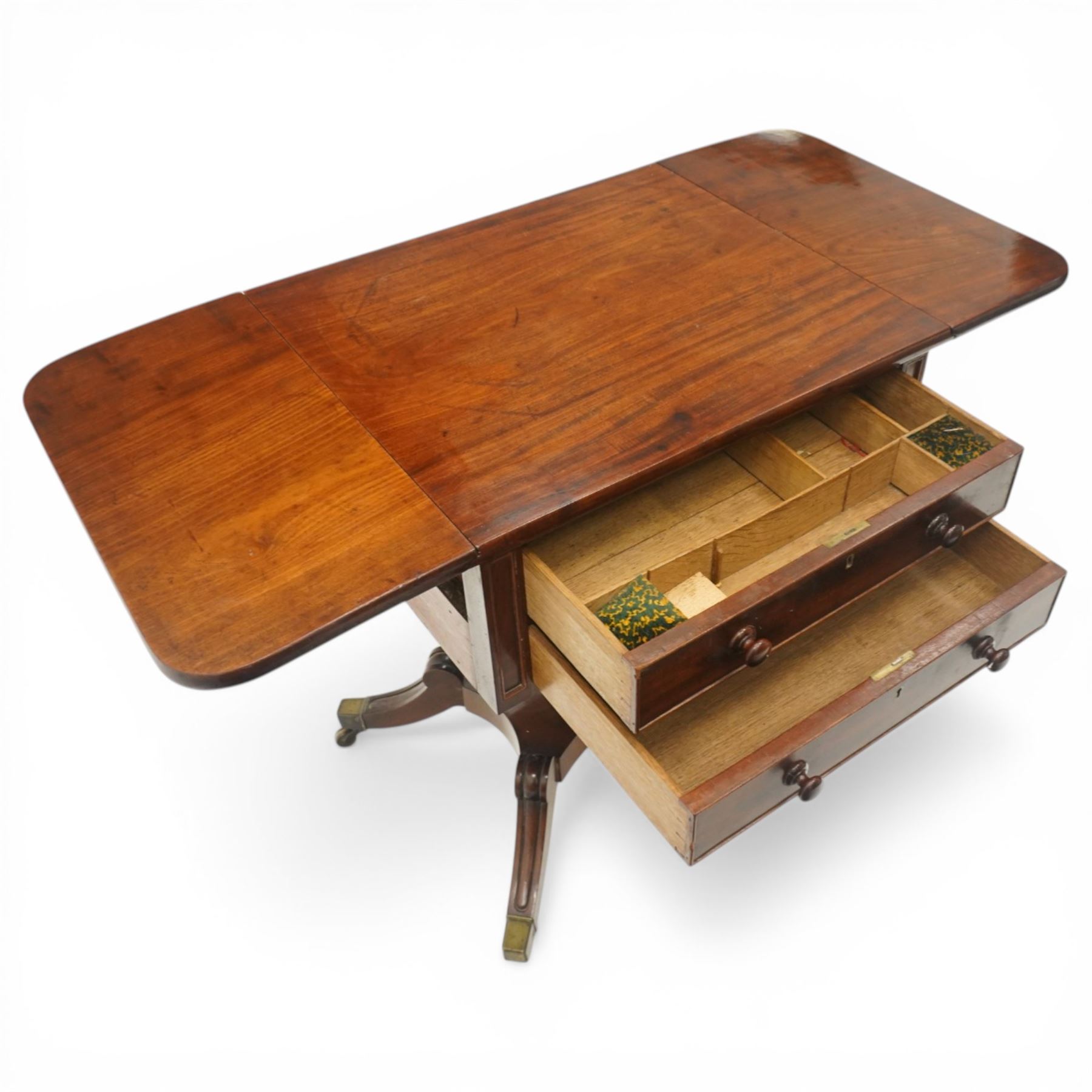 Georgian style mahogany drop leaf work table, rectangular top with rounded drop leaves over two frieze drawers with turned handles, raised on turned pedestal support with four outswept legs terminating in brass caps and castors