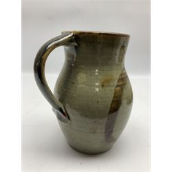 Michael Leach (British 1913-1985) for Yelland pottery; two large glazed stoneware plates with dark brown stylised decoration upon oatmeal ground, together with a jug in merging blue, green and brown, all with impressed marks beneath, largest plate D37cm