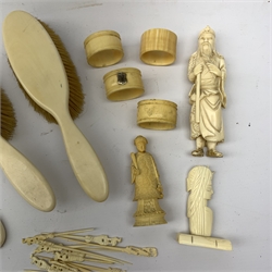 A selection of assorted ivory and bone items, to include a Japanese okimono modelled as a sage, four napkin rings, three with hallmarked silver cartouches, a early 20th century dressing table set, comprising hand held mirror, two hair brushes, two clothes brushes, and glove stretchers, plus a number of picks with carved figural terminals. 