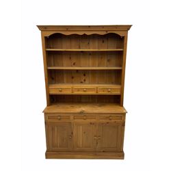 Pine dresser, three heights plate rack with drawers over sideboard fitted with drawers and cupboard, skirted base