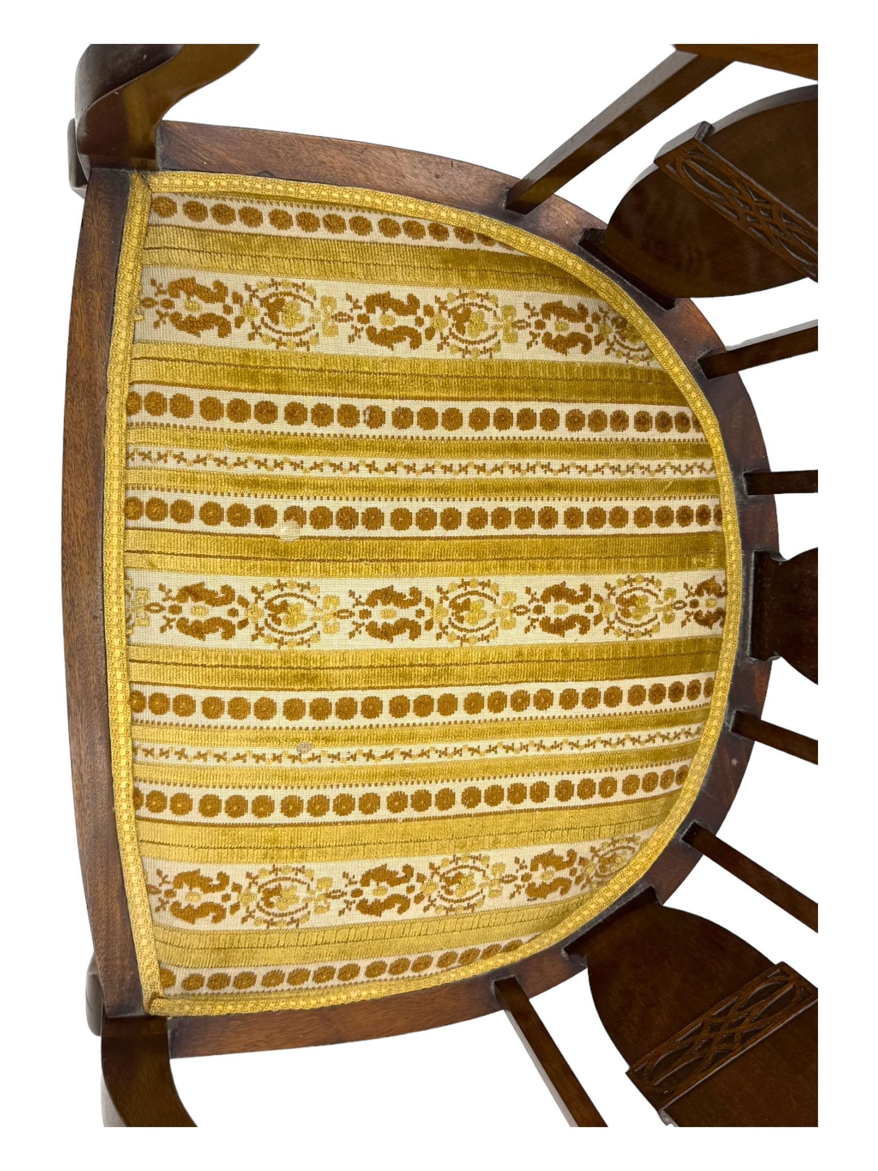 Late Victorian mahogany framed tub chair, rounded backrest with vertical splats and three carved oval medallions, upholstered seat in yellow patterned fabric, on cabriole supports