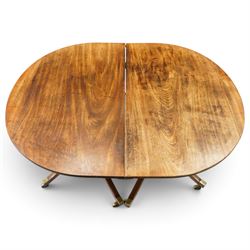 George III mahogany twin pedestal extending dining table, the twin D-ends with additional leaf, raised on twin turned pedestals terminating to four splayed supports with brass cups and castors