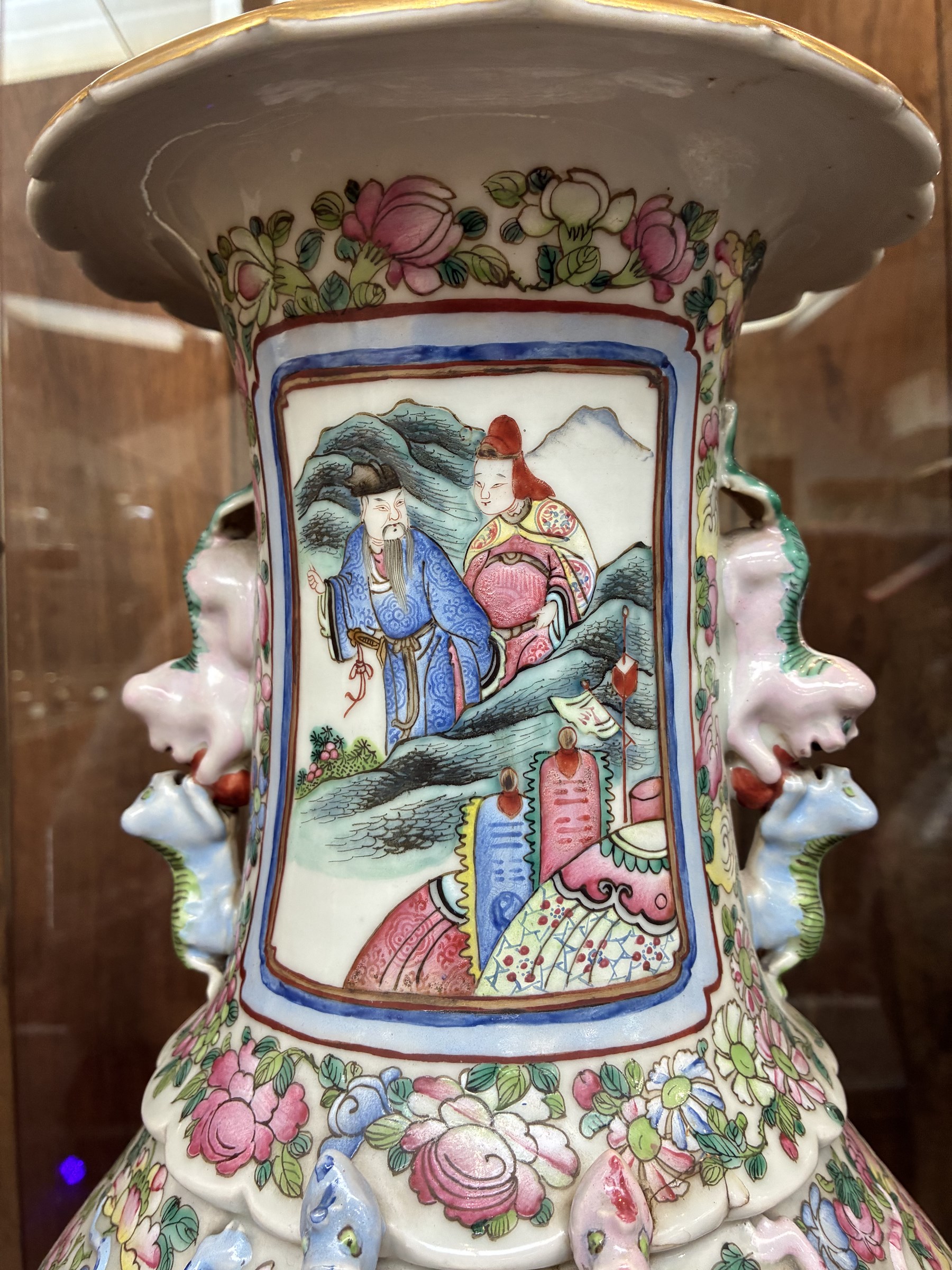 Large pair of 19th century Cantonese famille rose vases, each painted with various courtly scenes, including a display of warriors fighting on horseback before an official and his attendants, double Buddhist lion handles and applied at the shoulders with chilong, the lower band painted with Greek key motif, H58cm (2)