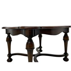 Figured mahogany coffee table, shaped moulded top with oval book-matched veneered panels, on turned supports united by waved X-shaped stretchers 