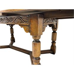 Early 20th century Jacobean design draw-leaf oak dining table, rectangular top with carved frieze depicting scrolling foliage and grape clusters, sliding extending leaves, raised on robust turned supports united by H-stretcher  