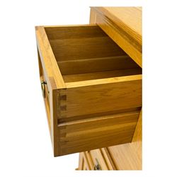 Frank Hudson - contemporary light oak chest, rectangular moulded top over two short and three long drawers, brass oval backplates with circular drop handles, on a moulded plinth base with bracket feet