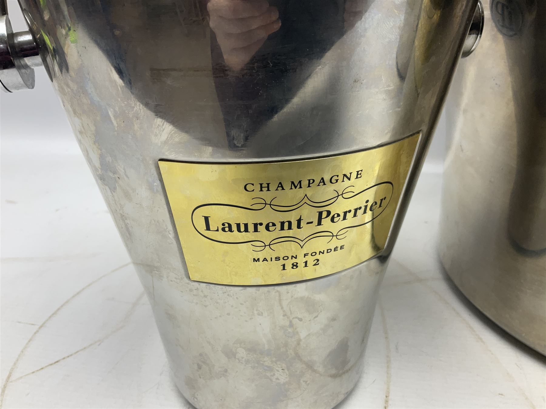Stainless steel Laurent-Perrier champagne bucket, with engraved brass plaque and grip to swing handle, together with two matching smaller, largest D38cm (3)