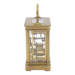 French-Edwardian 8-day timepiece carriage clock with a cylinder platform escapement, anglaise style brass case with four glass panels, dial with a polished gilt mask and foliate decoration, white enamel chapter with Arabic numerals and steel spade hands, . With Key. 