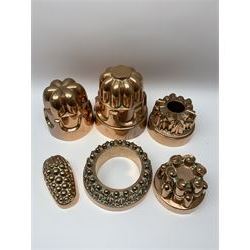 Six Victorian copper jelly moulds, five examples of castle type form, one example modelled as a bunch of grapes, largest H21cm