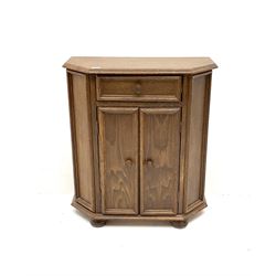 Victorian style oak cabinet, single short drawer above two cupboard doors enclosing two shelves, supported by pad feet