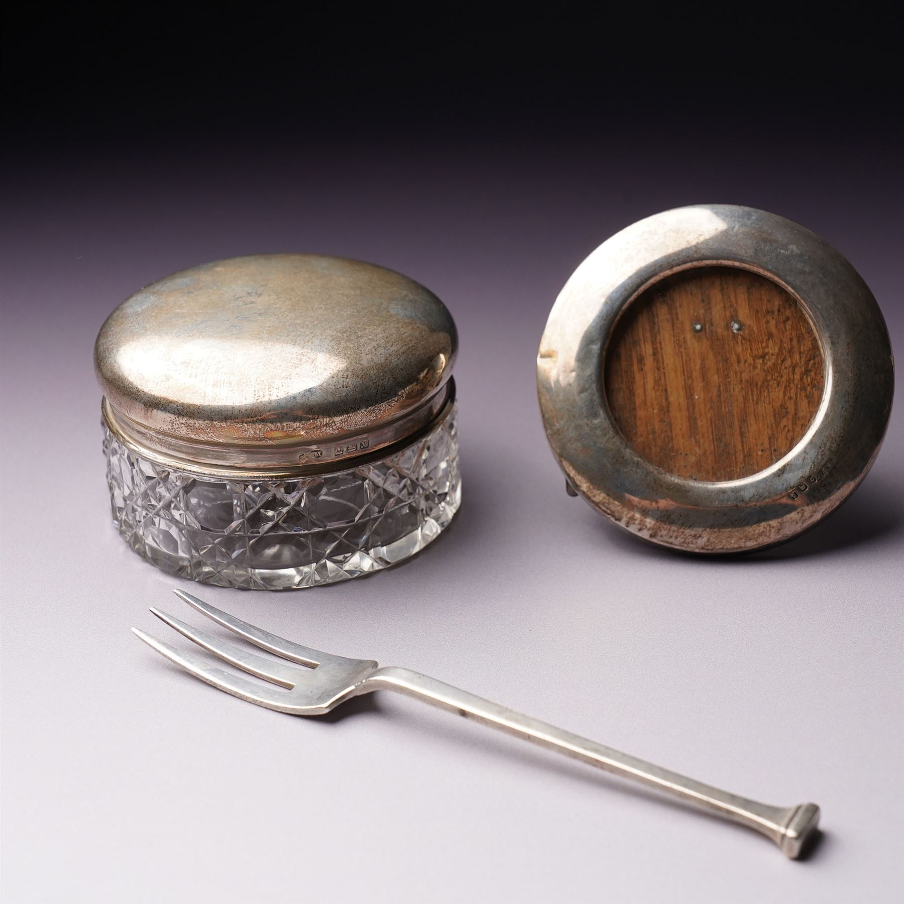 Silver topped glass trinket jar, small circular photograph frame and dessert fork