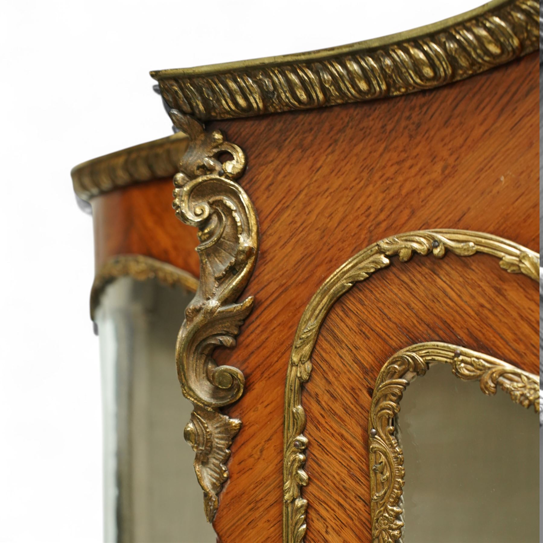 Louis XV revival kingwood Vernis-Martin serpentine fronted vitrine cabinet, arched top with gilt brass foliate mounts, glazed door with two shelves above three painted panels, depicting pastoral scenes, supported on out-swept cabriole legs with gilt brass mounts and sabots.