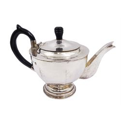 Modern Arts and Crafts style silver teapot, of circular faceted form, with hammered finish and ebonised wooden handle and finial, upon circular domed foot, hallmarked John Henry Pank, London 1994, with Hull town mark, H17cm