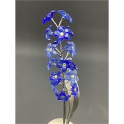 Eleven Swarovski Crystal flowers, to include violet, sunflower, delphinium, forget-me-not and lily-of-the-valley, each on stylised metal stems, tallest H23cm