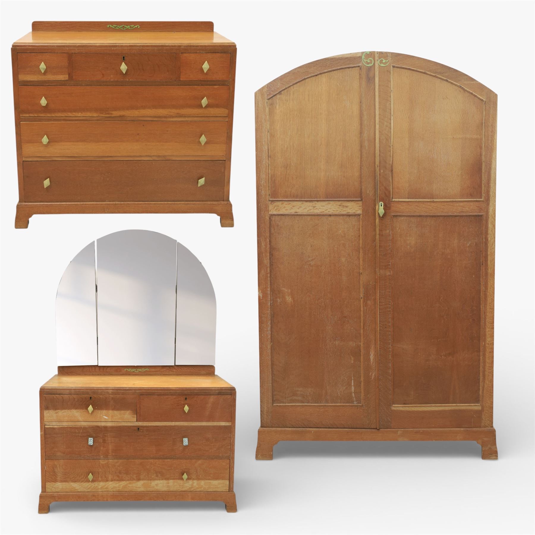 Early 20th century Art Deco bedroom suite, comprising double wardrobe, dressing table and chest of drawers, constructed in walnut with figured veneers and geometric banding, the wardrobe with arched top and panelled doors enclosing a fitted interior, the dressing table with rectangular top below a three panel mirror arrangement, fitted with two short over two long drawers, the chest with three short and three long drawers, each piece fitted with faceted handles and raised on shaped feet
Wardrobe (H 177cm, D 46cm, W 112cm)
Chest (H 85cm, D 48cm, W 92cm)
Dressing table (H 160cm, D 52cm, W 106cm)
