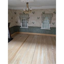 Two modern three storey dolls houses, each painted green with decorated interiors, both upon a single white wooden base, together with a large collection of dolls house furniture, accessories and figures 