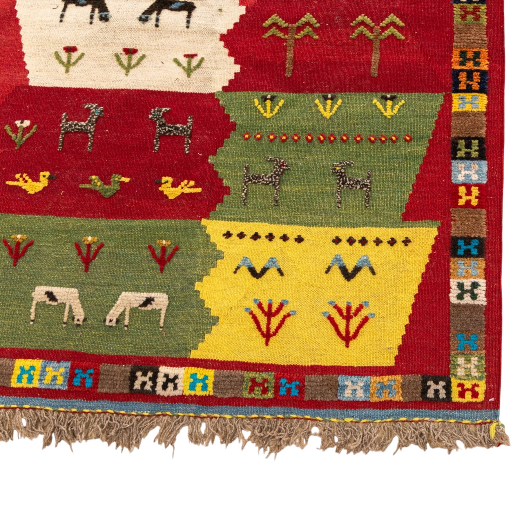 South West Persian Qashqai kilim, the field arranged with stepped polychrome panels depicting stylised camels, goats, cattle and birds, interspersed with trees and flowering stems, enclosed by a red border with multicoloured geometric devices