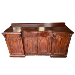 Large Victorian mahogany sideboard, raised back, central banded serpentine frieze drawer over double arched panelled cupboard, flanked by two single cupboards enclosing sliding trays and drawers