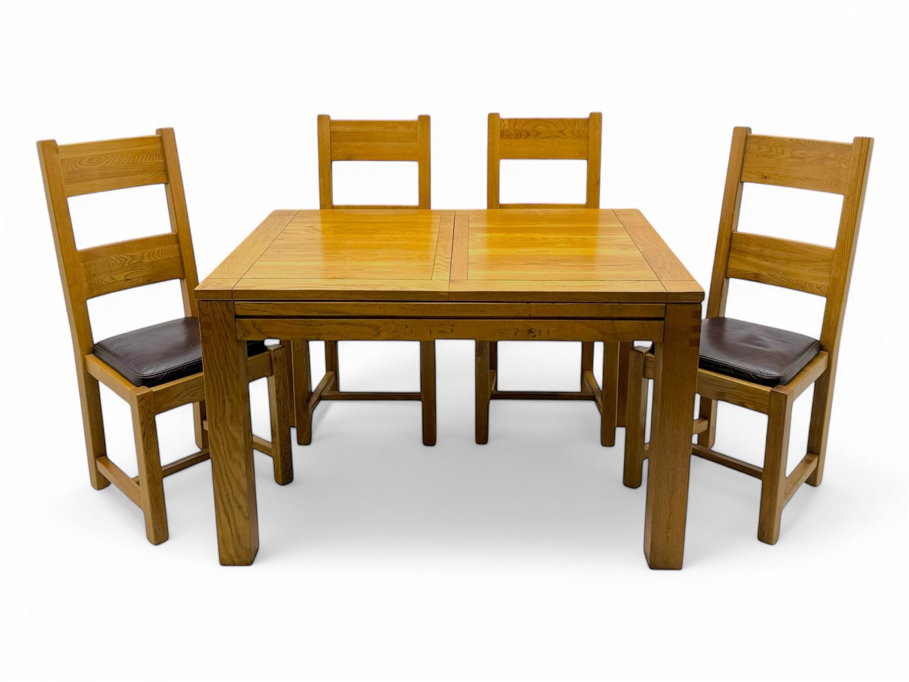 Contemporary oak dining table, rectangular panelled top with integral extension leaf, raised on square supports; set of four oak ladder-back chairs with padded brown seats